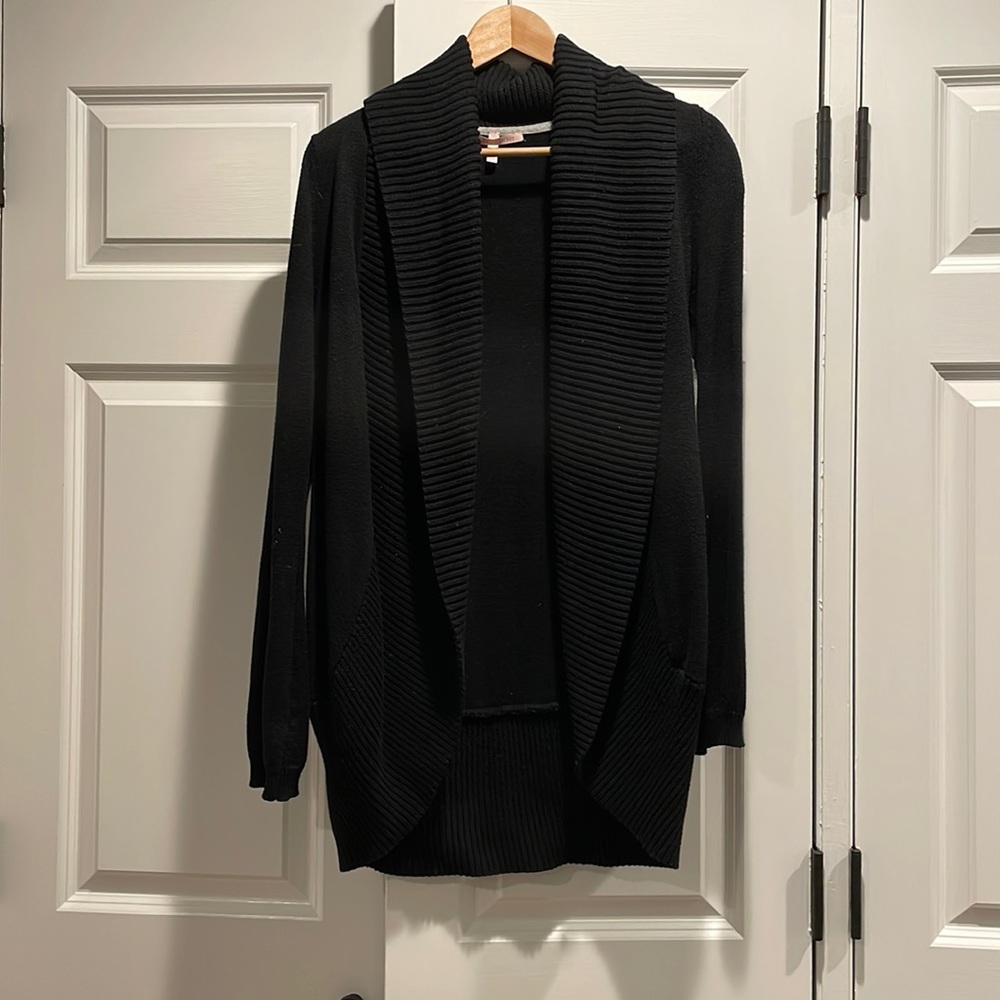 Black cardigan, made of cotton. Bits at the hips. Very warm.